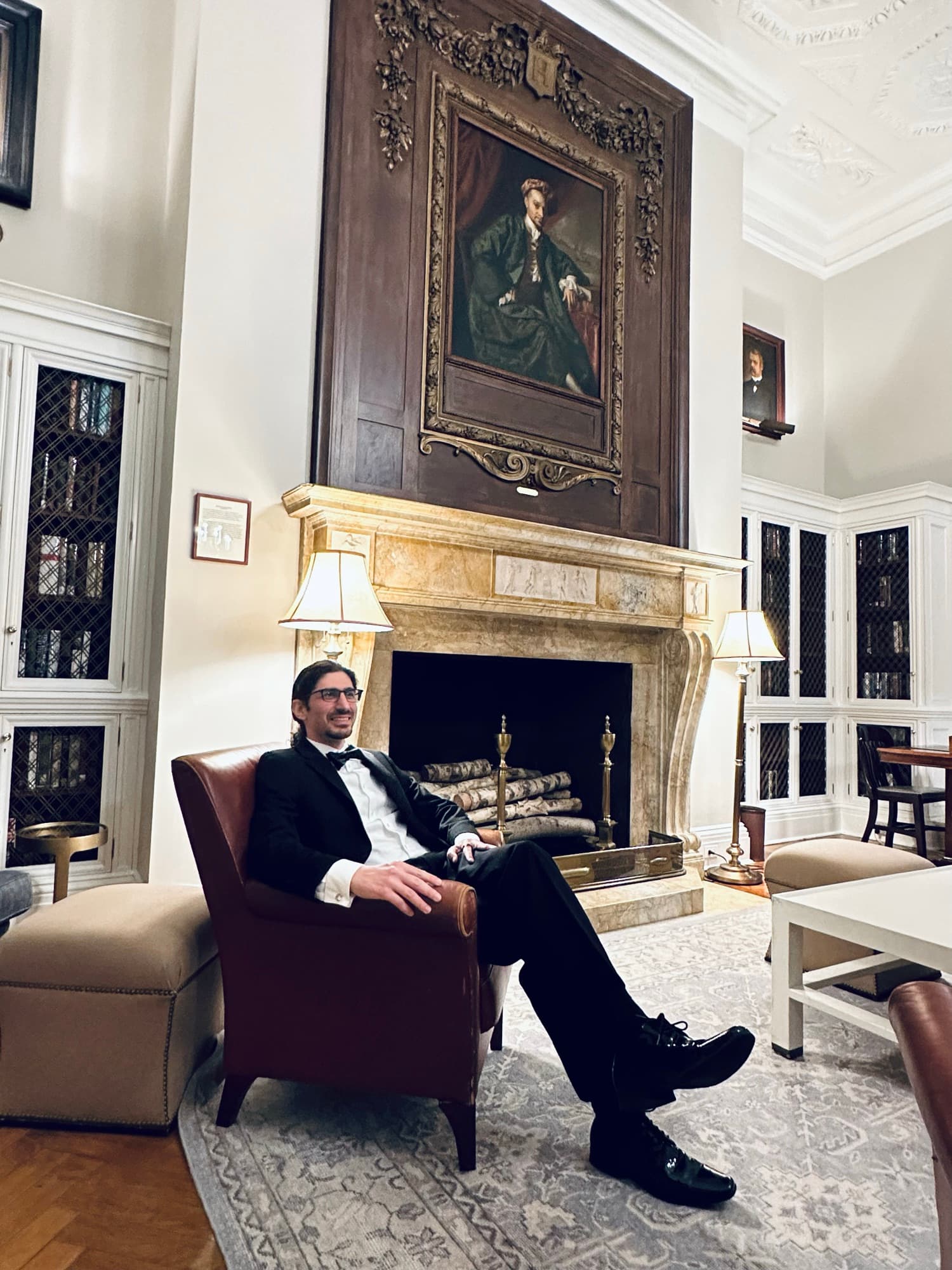 Carlo Mahfouz in black tie, seated by a fireplace