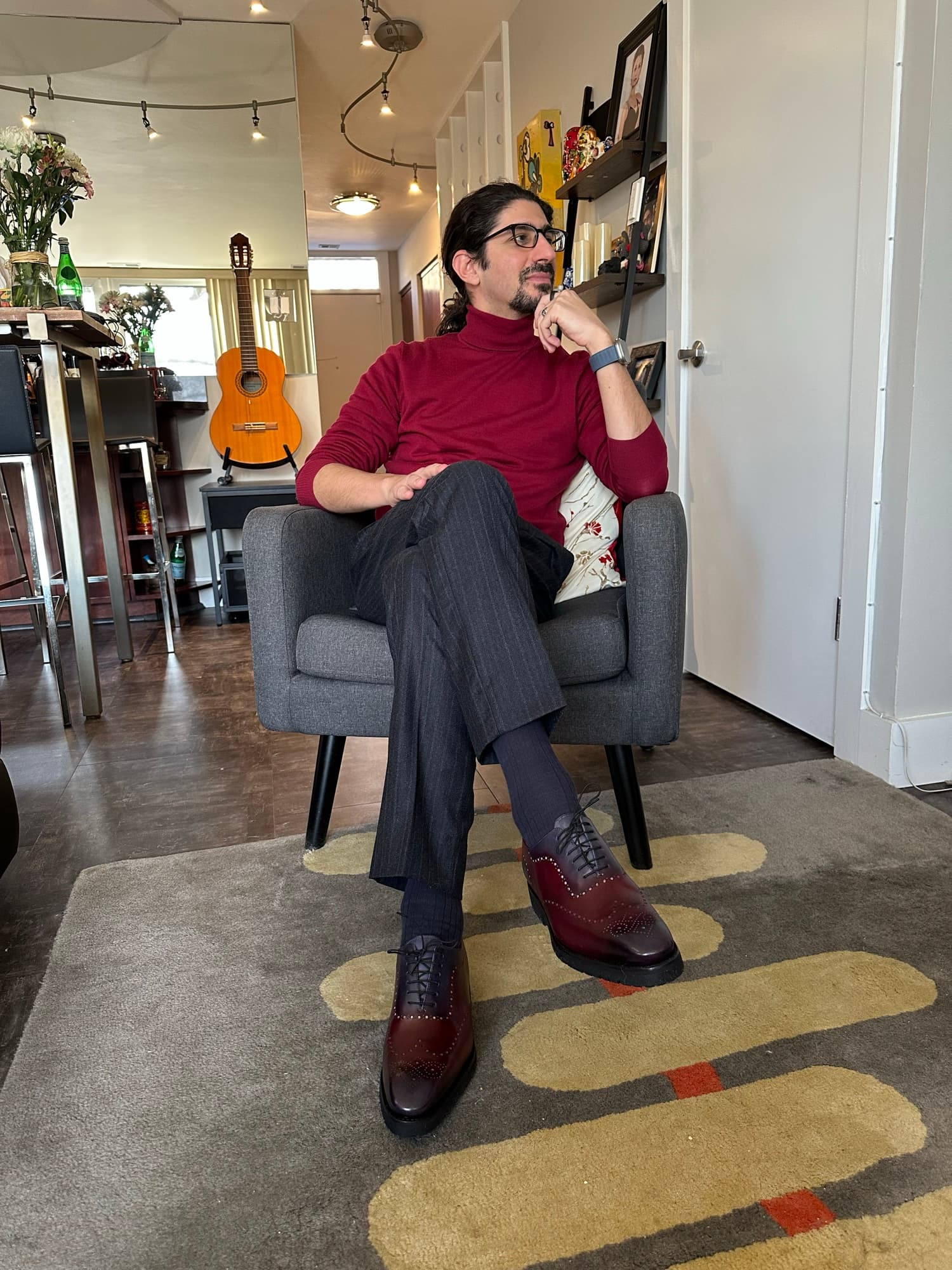 Carlo Mahfouz at home, a guitar behind him